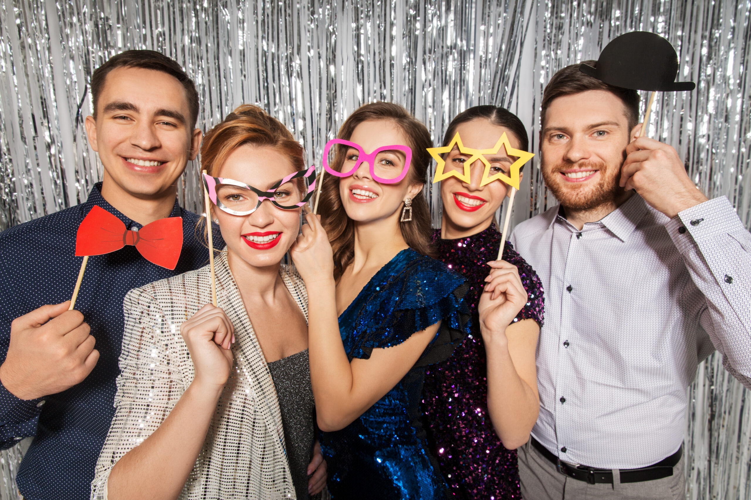 celebration, fun and holiday concept - happy friends posing with party props